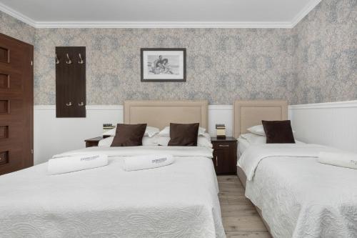 two beds in a room with two at Zwierzyńscy Residence in Pobierowo