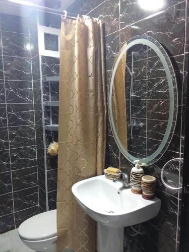 a bathroom with a sink and a mirror at Cozy two bedroom apartment in Meknès