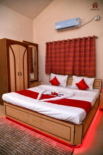 a bedroom with a large bed with red pillows at CHOCOLATE VILLA Mahabaleshwar in Mahabaleshwar