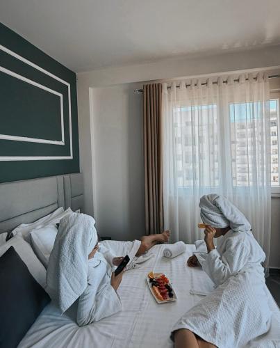 two people in towels laying on a bed at Hotel LEODORI 3 suites in Shëngjin