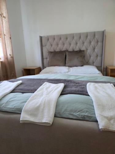 a large bed with two white towels on it at Alex in Castlerea