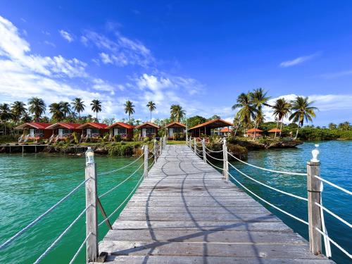 a wooden bridge over a body of water with houses at Panglima Resort Bum Bum Island, Semporna in Semporna