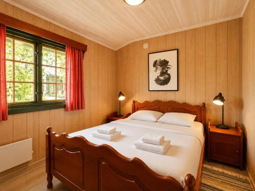a bedroom with a large bed with two towels at Briskebu, cosy cabin by ski slopes in Geilo