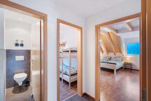 a bathroom with a mirror and a bedroom with a bunk bed at Ferienwohnung Joosenhof in Winden im Elztal