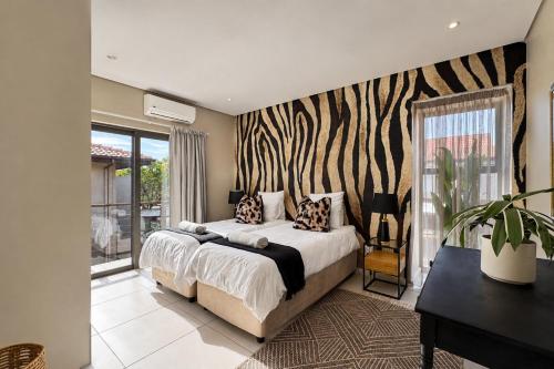 a bedroom with a bed with a zebra print wall at Ballito Zimbali Wedge in Ballito