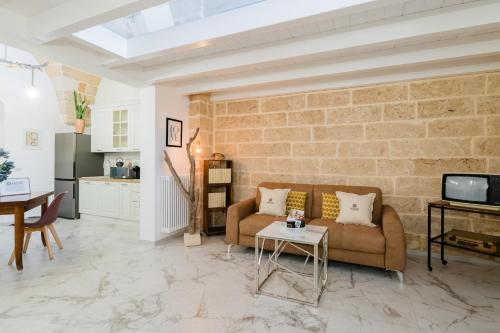 a living room with a couch and a brick wall at Melodia del Salento - Lecce Selection in Surbo
