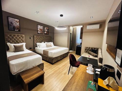 a hotel room with two beds and a couch at Hotel Shopi Residence in Elbasan