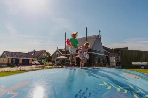 two children standing on top of a swimming pool at Velthorst 6 in Warmond