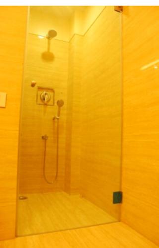 a shower with a glass door in a bathroom at Hotel Rajtara in Satara