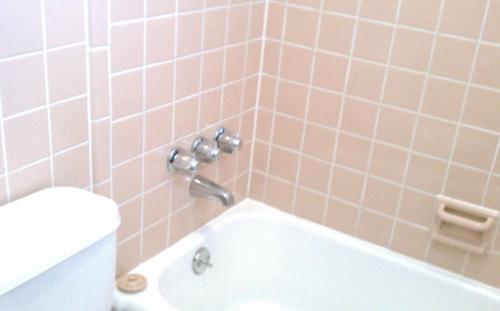 a bathroom with pink tiled walls and a bath tub at Valley Motel Pittsburgh in Harmarville