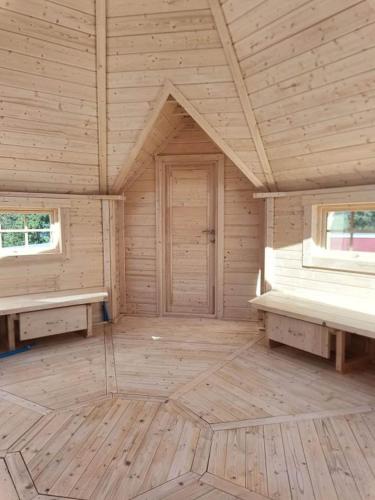 an empty room with two benches in a wooden cabin at Le Village des Pingouins à Porspoder in Porspoder