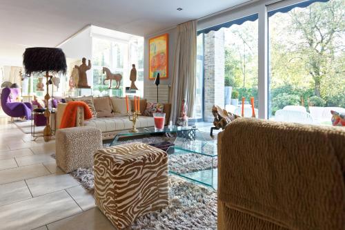 a living room with a couch and a glass table at Villa Tiffany in Braine-lʼAlleud