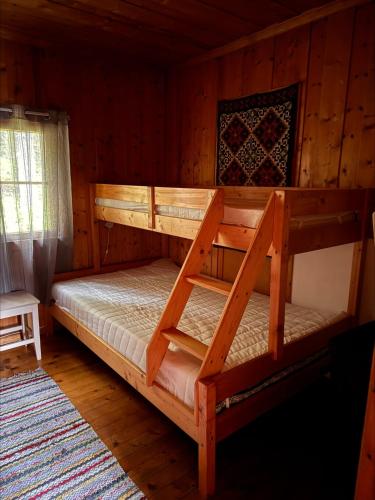 a bedroom with two bunk beds in a cabin at Simple and cozy forest cabin in Eidsstryken