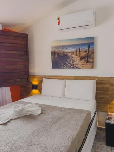a bedroom with a bed with a picture on the wall at Pousada Porto Amazônia in Porto De Galinhas