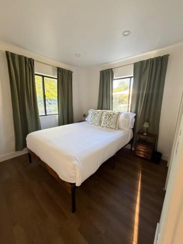 a bedroom with a large white bed in front of windows at Two Trees Retreat in Salt Lake City