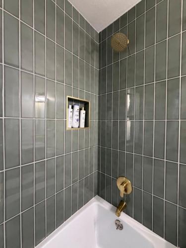 a bathroom with a tub and green tiles at Two Trees Retreat in Salt Lake City