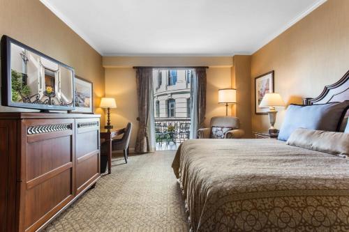 a hotel room with a bed and a flat screen tv at Omni Royal Orleans Hotel in New Orleans