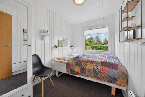a bedroom with a bed and a chair and a window at Family Holiday Home with Jacuzzi and Fireplace in Hejls