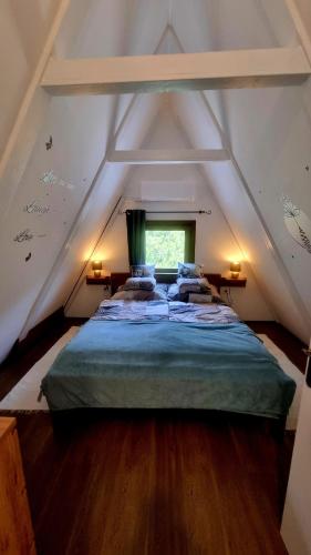 a bedroom with a large bed in the attic at Ariel 2 Vendégház in Pilismarót