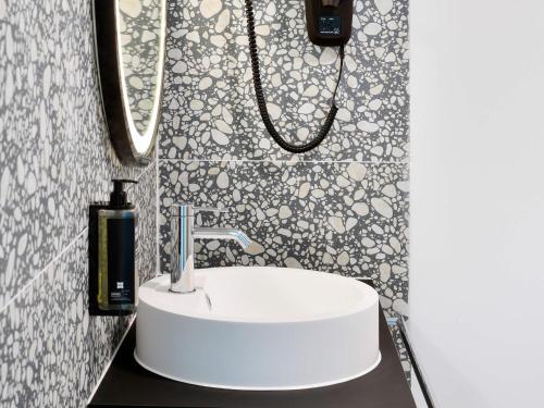 a bathroom with a white sink and a mirror at ibis Styles Bredene in Bredene
