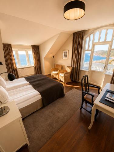 a hotel room with a large bed and a desk at Grand Hôtel Mölle in Mölle