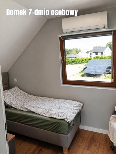 a bed in a tiny house with a window at Górskie Marzenie - Apartament i Domek z sauną blisko Zatora i Energylandii in Przeciszów