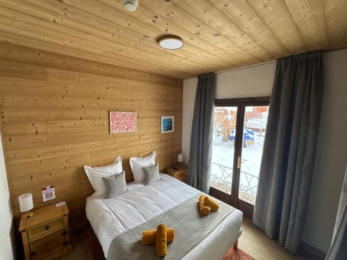 a bedroom with a bed with two teddy bears on it at Logis Hôtel Le Cairn in Les Deux Alpes