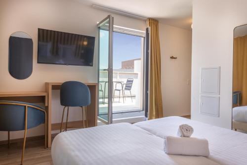 a bedroom with a bed and a balcony with a tv at Ibis Styles Paris Pont d'Ivry in Ivry-sur-Seine