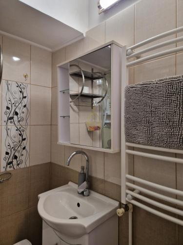 a bathroom with a sink and a mirror at Iris ultracentral apartment in Mangalia