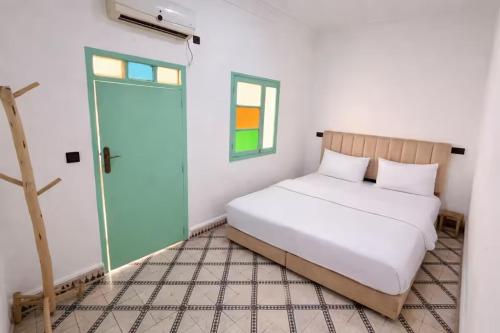 a bedroom with a bed and a window and a door at Palm Hostel in Marrakesh