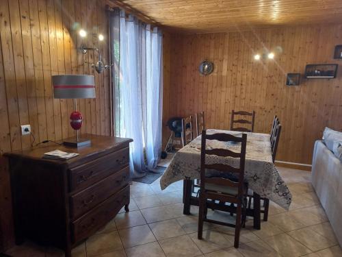 a dining room with a table and chairs and a couch at Isa's Little Cottage in Saint-Bonnet-de-Chirac