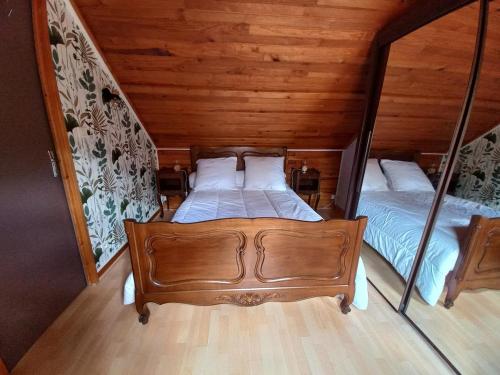 two beds in a room with wooden walls at Isa's Little Cottage in Saint-Bonnet-de-Chirac