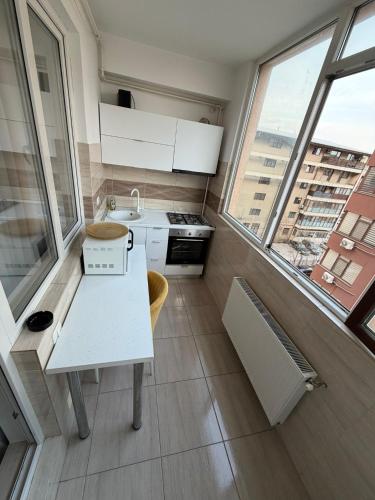 a kitchen with a white table and some windows at RC RelaxApart 314 in Dudu