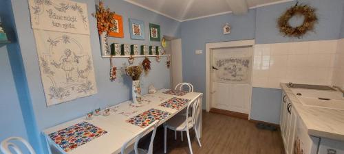 a room with a table with drawings on the wall at Malowany Domek in Przymiłowice