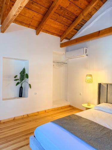 a bedroom with a bed and a plant on the wall at Κουρείον Kourion in Agios Vlasios