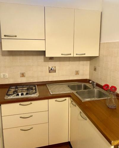 una cocina con armarios blancos y un fregadero en Hotel Dali, en Florencia