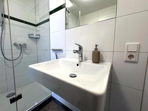 a white bathroom with a sink and a shower at Bad Oeynhausen - City, Küche, Netflix, Wifi, zentral, StudioApartment in Bad Oeynhausen