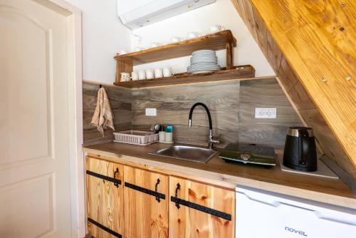a kitchen with wooden cabinets and a sink at Ali-pašin Konak in Gusinje