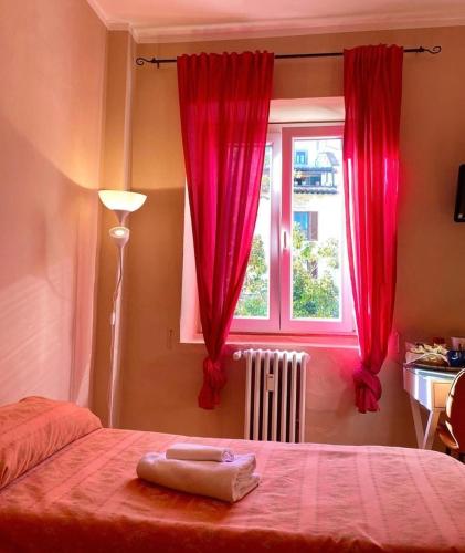 un dormitorio con una cama con cortinas rojas y una ventana en Hotel Dali, en Florencia