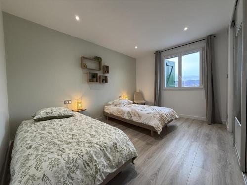 a bedroom with two beds and a large window at Ibarnia in Suhescun