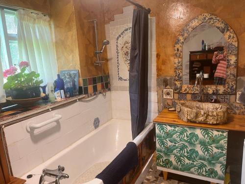 a bathroom with a bath tub and a sink at Fabulous Glamping Yurt in Bantry