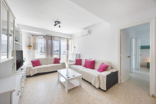 a living room with two white couches and pink pillows at Valdelagrana en Primera Linea in El Puerto de Santa María