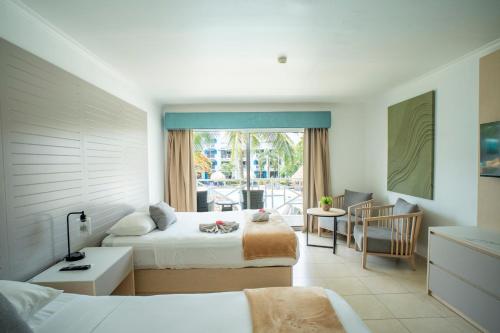 a hotel room with two beds and a balcony at Playa Blanca Beach Resort - All Inclusive in Playa Blanca