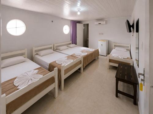 a room with three beds and a table in it at Center 1 Hotel in Fortaleza