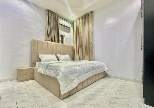 a bedroom with a large bed with a mirror at Serene 5 Bedroom Duplex With Exclusive Compound in Iseri