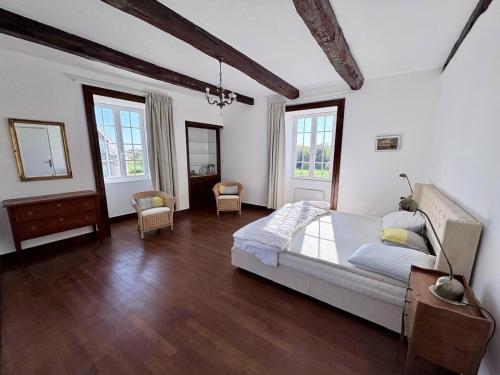 a bedroom with a bed and wooden floors and windows at Longère près des plages, 11 pers 5 chambres! in Trégunc