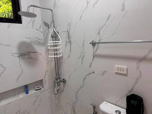 a bathroom with a shower with marble walls at Urban Canopy City Forest Staycation in Tigbawan