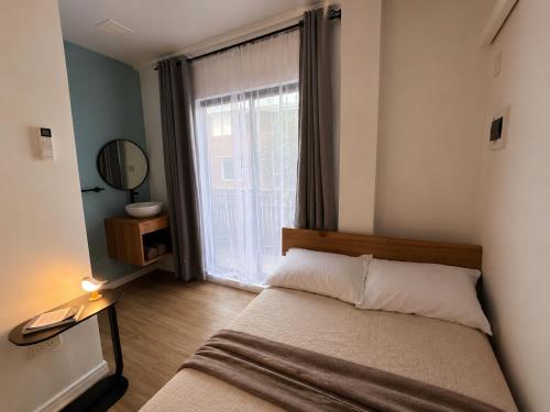 a bedroom with a bed and a large window at GASA Guesthouse in Compostela