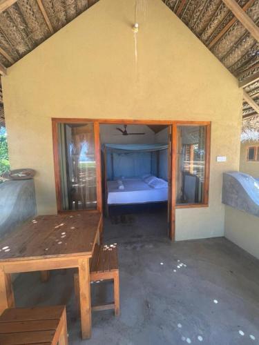 a room with a bed and a wooden table at Peanut Farm Cabanas -Surf in Panama