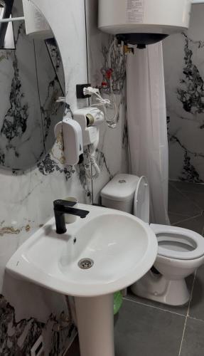 a bathroom with a white sink and a toilet at Tau Saty in Saty